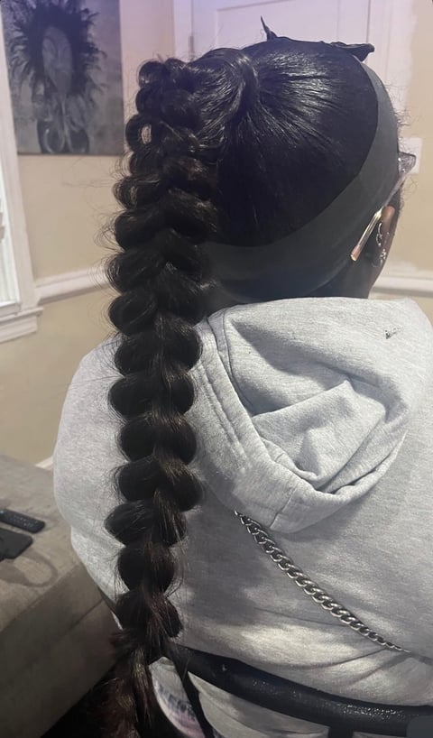 Person wearing gray hoodie with braided hair